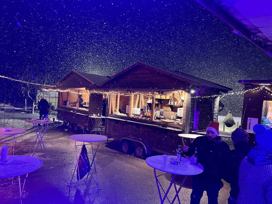 Weihnachtsmarkt-Hütten am Pierhubergut bei Schnee und Lichterketten