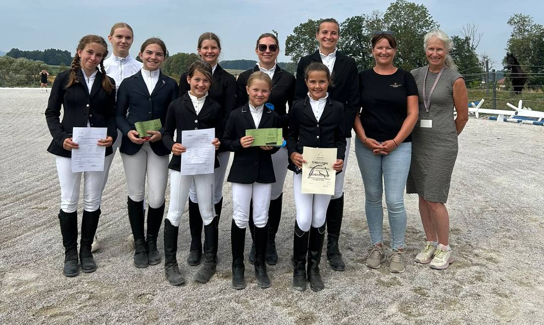 Gruppenfoto der Prüflinge mit Urkunden und Reiternadeln auf dem Reitplatz